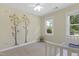 Bright bedroom with a ceiling fan, tree decal, and a large window with outside views at 110 Chapelwood Way, Cary, NC 27518