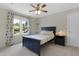 Cozy bedroom featuring a wood accent wall, a large window, and a blue queen-size bed at 110 Chapelwood Way, Cary, NC 27518