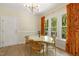 Dining area featuring bright windows with orange curtains, modern light fixture, and light wood floors at 110 Chapelwood Way, Cary, NC 27518
