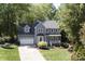 Charming gray two-story home with an attached two-car garage and a manicured front lawn at 110 Chapelwood Way, Cary, NC 27518