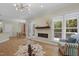 Open-concept living area with modern fireplace, hardwood floors, and large windows offering natural light at 110 Chapelwood Way, Cary, NC 27518