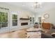 Bright living room with sleek fireplace, hardwood floors, and large windows, featuring a comfortable seating area at 110 Chapelwood Way, Cary, NC 27518