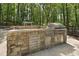 Outdoor kitchen and grill area with stone counter, stainless steel grill, and storage at 110 Chapelwood Way, Cary, NC 27518