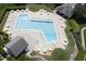 Aerial view of a large pool with an expansive sun deck and outdoor tables and chairs at 110 Chapelwood Way, Cary, NC 27518