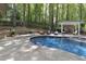 Backyard pool with a waterfall feature, lounge area, and outdoor fireplace at 110 Chapelwood Way, Cary, NC 27518