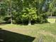 Lush backyard with mature trees, a storage shed, and ample space for recreation and gardening at 1102 Poplar Ave, Garner, NC 27529