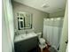 Bathroom with modern vanity, LED mirror, and shower-tub combination at 1102 Poplar Ave, Garner, NC 27529