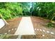 Backyard patio space with stonework pathway, lush greenery, and mature trees providing a serene and private setting at 1124 Hardimont Rd, Raleigh, NC 27609