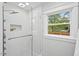 Elegant shower with white tile, glass door, and window with a view to outside at 1124 Hardimont Rd, Raleigh, NC 27609
