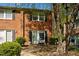 Charming brick townhome with black shutters, well-maintained landscaping, and inviting entrance at 115 Coleridge Ct, Carrboro, NC 27510