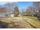 Large, partially-fenced backyard with mature trees and space for gardening at 115 Higbee St, Durham, NC 27704