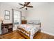 Comfortable bedroom with hardwood floors, a patterned bedspread, and natural light from the window at 1208 Steinbeck Dr, Durham, NC 27703