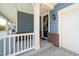 Inviting porch area with white railings and brick accents, leading to the front door with wreath at 1208 Steinbeck Dr, Durham, NC 27703