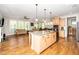 Open-concept kitchen featuring a large island, stainless steel appliances and hardwood floors at 1208 Steinbeck Dr, Durham, NC 27703