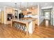Well-designed kitchen showcasing an island with seating, custom cabinets, and hardwood floors at 1208 Steinbeck Dr, Durham, NC 27703
