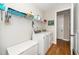 Functional laundry room with washer, dryer, shelving, storage and hardwood floors at 1208 Steinbeck Dr, Durham, NC 27703
