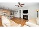 Open-concept living room featuring hardwood floors, a fireplace, and seamless flow into the kitchen at 1208 Steinbeck Dr, Durham, NC 27703