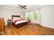 Comfortable main bedroom with hardwood floors, a ceiling fan, and natural light at 1208 Steinbeck Dr, Durham, NC 27703