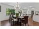 Bright dining room with dark wood table, stylish chandelier, and open flow to kitchen at 1310 Mayfair Rd, Raleigh, NC 27608