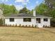 Charming white brick home with new landscaping including dark trim windows and an inviting entryway at 1310 Mayfair Rd, Raleigh, NC 27608