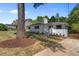 Beautiful white brick home with lush landscaping, mature trees, and a well-maintained lawn at 1310 Mayfair Rd, Raleigh, NC 27608