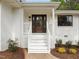 Inviting front porch with classic white railings, a stylish wood door, and manicured landscaping at 1310 Mayfair Rd, Raleigh, NC 27608