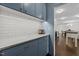 Kitchen with stylish blue cabinetry, subway tile backsplash, and marble countertops at 1310 Mayfair Rd, Raleigh, NC 27608