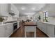 Spacious open kitchen with white cabinets, hardwood floors, and view to dining area at 1310 Mayfair Rd, Raleigh, NC 27608