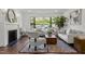 Bright living room features large window, fireplace, zebra rug, and comfortable seating arrangement at 1310 Mayfair Rd, Raleigh, NC 27608