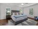 Bright main bedroom features hardwood floors, a large bed, and several windows at 1310 Mayfair Rd, Raleigh, NC 27608