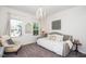 Stylish bedroom with a daybed, white chandelier, and abundant natural light at 1403 Chipping Dr, Apex, NC 27502
