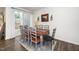 Dining room with seating for eight, sliding glass door, decorative wall art and hardwood flooring at 1403 Chipping Dr, Apex, NC 27502