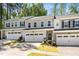 Attractive townhome featuring a two-car garage, manicured landscaping, and a welcoming front entrance at 1403 Chipping Dr, Apex, NC 27502