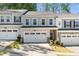 Charming townhome with attached garages, neutral siding, well manicured landscaping, and a concrete driveway at 1403 Chipping Dr, Apex, NC 27502
