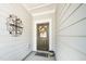 Inviting front door with a decorative wreath, a 'Welcome' mat, and an ornate wall decoration at 1403 Chipping Dr, Apex, NC 27502