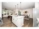 Bright, open kitchen featuring a central island with modern pendant lighting and stainless steel appliances at 1403 Chipping Dr, Apex, NC 27502