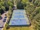 Aerial view showcasing tennis and basketball courts, surrounded by lush trees and greenery at 1420 Willowleaf Way, Apex, NC 27502