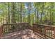 Backyard deck surrounded by lush green trees and a view to the natural backdrop at 1420 Willowleaf Way, Apex, NC 27502