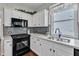 Close-up of a kitchen with modern appliances and bright white cabinets at 1420 Willowleaf Way, Apex, NC 27502