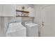 Well-equipped laundry room with white washer, dryer, cabinets, and wood shelf at 1420 Willowleaf Way, Apex, NC 27502