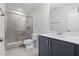 Neutral bathroom featuring a glass enclosed shower, single sink vanity, and tile flooring at 1448A Maplewood Dr, Durham, NC 27704