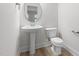 This powder room features a pedestal sink, a toilet, and light wood-look floors at 1448A Maplewood Dr, Durham, NC 27704
