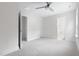Spacious bedroom with neutral carpet, white walls, ceiling fan, and multiple doorways at 1448A Maplewood Dr, Durham, NC 27704