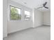 This carpeted bedroom features two windows, a ceiling fan, and neutral paint at 1448A Maplewood Dr, Durham, NC 27704