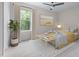 Cozy bedroom with a light gray rug, a window with curtains, bed, and a ceiling fan at 1448A Maplewood Dr, Durham, NC 27704