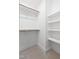 Bright walk-in closet featuring carpet flooring, white walls, multiple shelves, and rods for maximum storage at 1448A Maplewood Dr, Durham, NC 27704