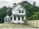 Two-story home boasts white siding, black metal roof accents, and a newly installed wooden fence at 1448A Maplewood Dr, Durham, NC 27704