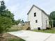 Rear exterior view of a two-story home featuring new siding, a wooden deck, and a fenced yard at 1448A Maplewood Dr, Durham, NC 27704