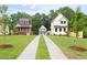 A long driveway leads to three attractive houses, surrounded by mature trees and greenery at 1448A Maplewood Dr, Durham, NC 27704