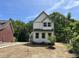 Charming two-story home features a white exterior, gray trim, and a cozy front porch at 1448A Maplewood Dr, Durham, NC 27704